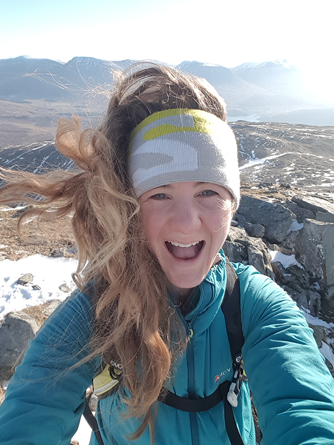 Selfie of Cairn Project Ambassador Annie Le smiling big on a mountaintop 