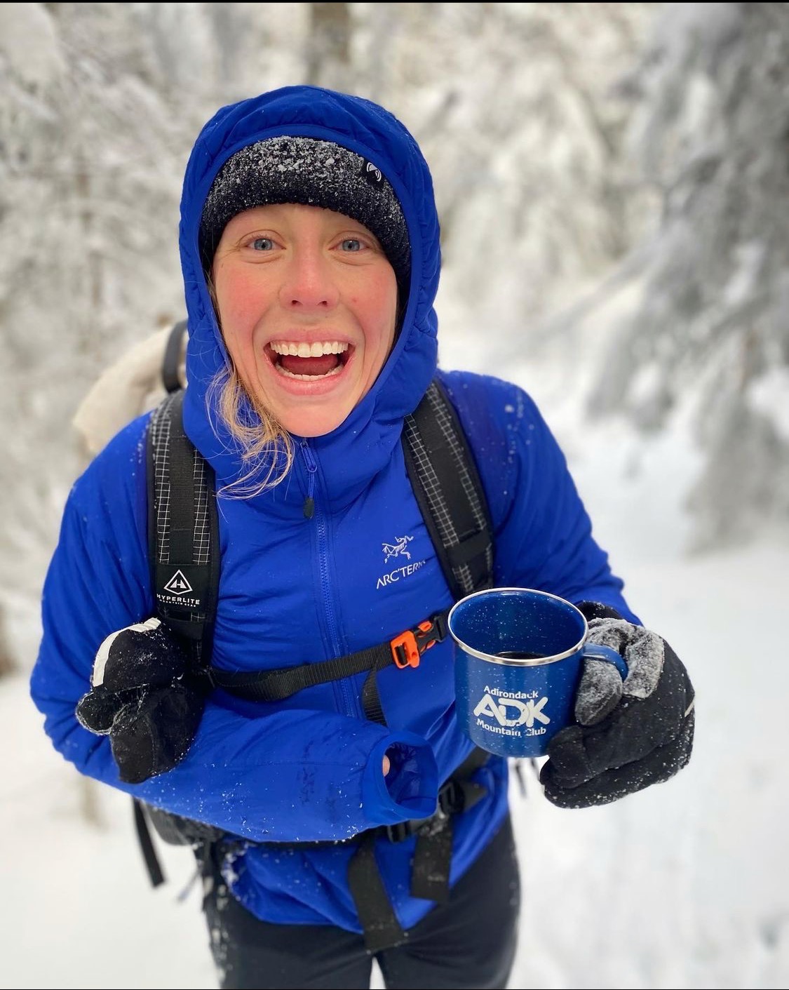 Sarah Funk smiles holding a coffee mug in the snow